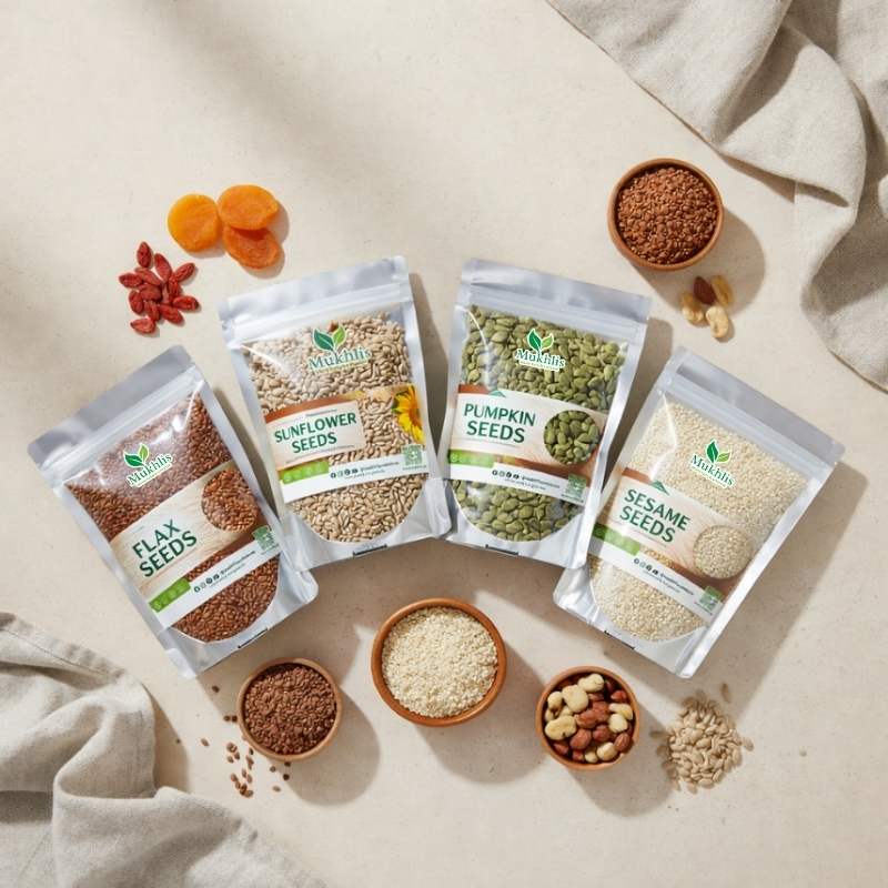 Mukhlis organic seed bundle featuring flax seeds, sunflower seeds, pumpkin seeds, and sesame seeds in premium resealable pouches arranged on a beige flat-lay background